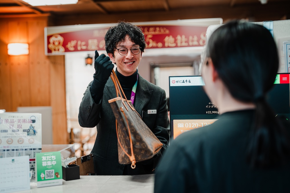 棚の商品を手に取り確認するスタッフの写真